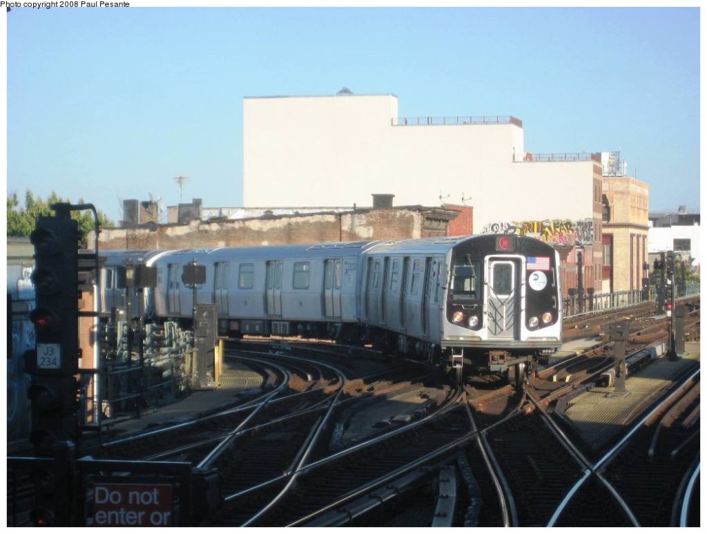 An M train passes at grade over the J train track causing delays.  Photo by Paul Pesante via nycsubway.org